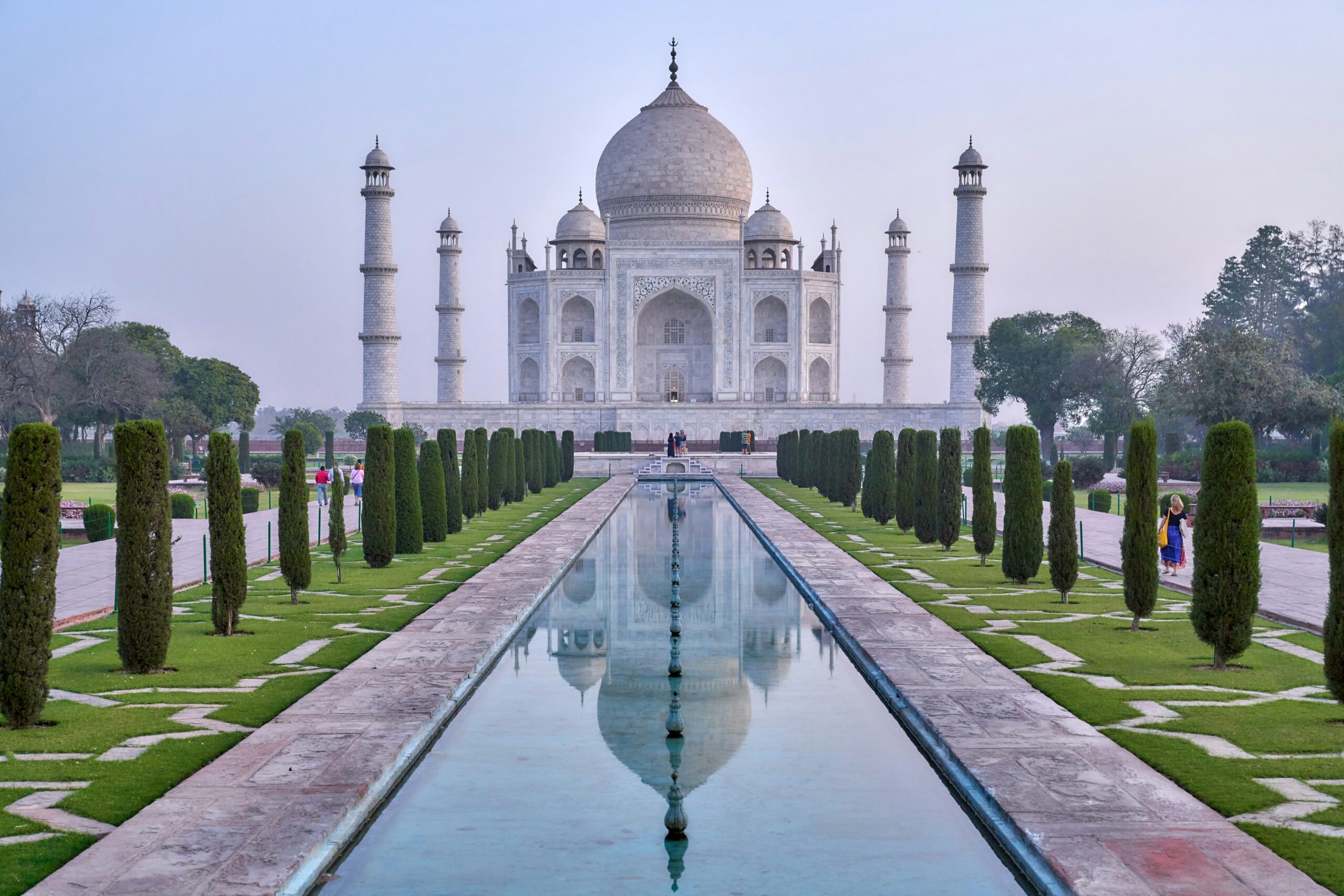 A long diatnce photo of the Taj Mahal with the fountain in the foreground