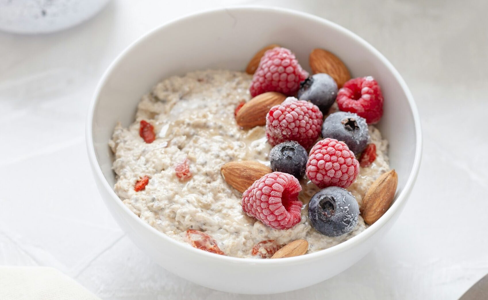 Bowl of porridge with fruit in a white bowl